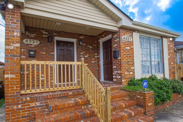 view of exterior entry featuring covered porch