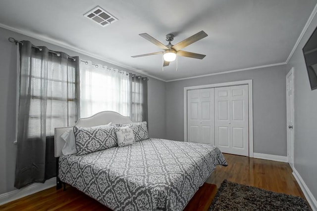 bedroom featuring ornamental molding, a closet, ceiling fan, and dark wood-type flooring