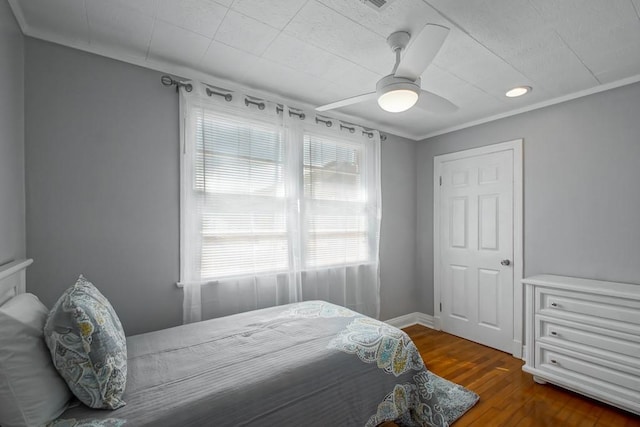 bedroom featuring ornamental molding, ceiling fan, and dark hardwood / wood-style flooring