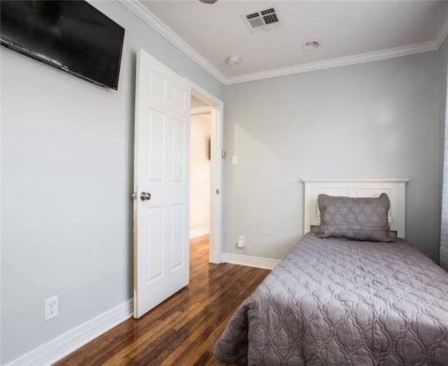 bedroom with dark hardwood / wood-style floors and ornamental molding