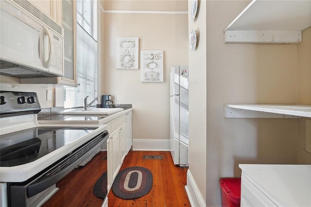 kitchen with dark wood-type flooring, white cabinets, electric range oven, sink, and extractor fan