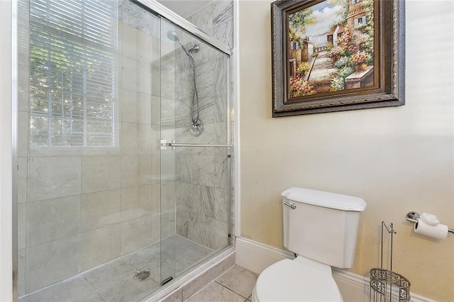 bathroom featuring walk in shower, tile patterned floors, and toilet