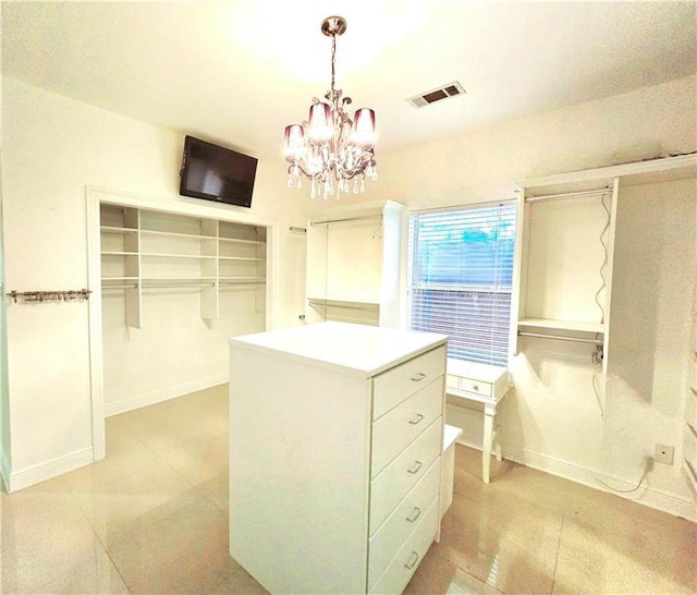 spacious closet featuring a chandelier