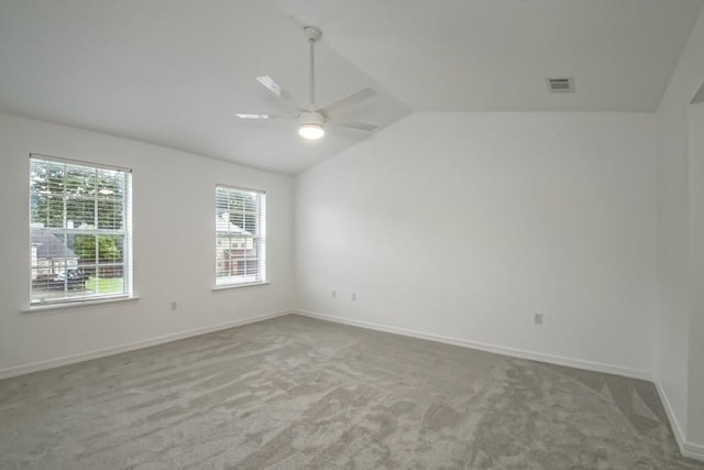 unfurnished room featuring visible vents, ceiling fan, carpet, and vaulted ceiling