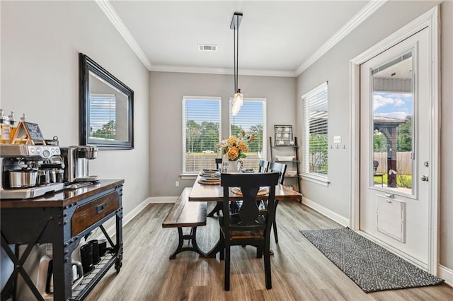 dining area with ornamental molding and wood-type flooring