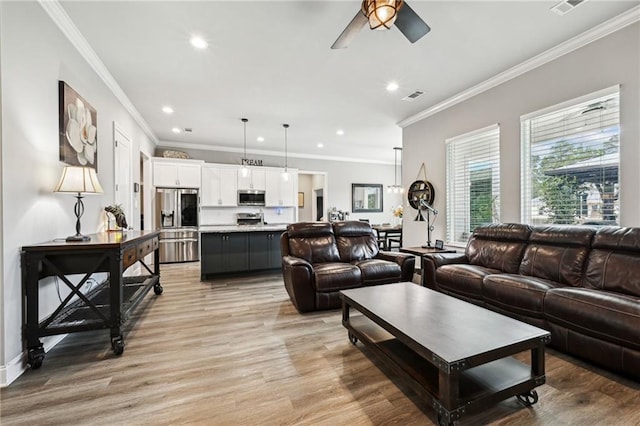 living room featuring light hardwood / wood-style flooring, ceiling fan, and crown molding