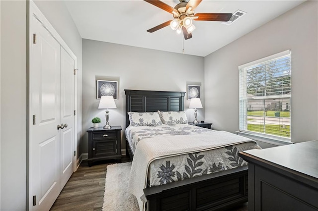 bedroom with dark wood-type flooring, a closet, and ceiling fan