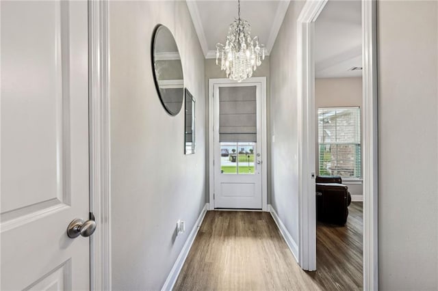 doorway to outside with hardwood / wood-style flooring, a chandelier, and ornamental molding