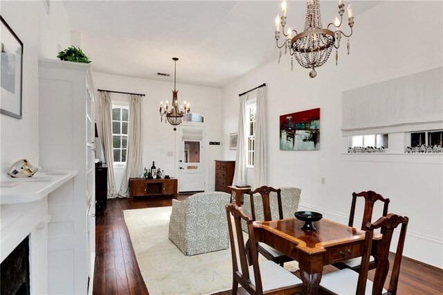 dining area featuring dark hardwood / wood-style flooring and an inviting chandelier