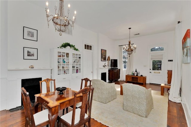 dining space with hardwood / wood-style flooring and an inviting chandelier