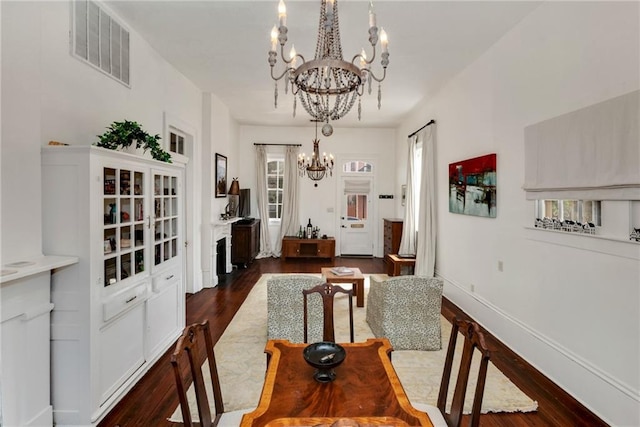 interior space with dark wood-type flooring and a chandelier