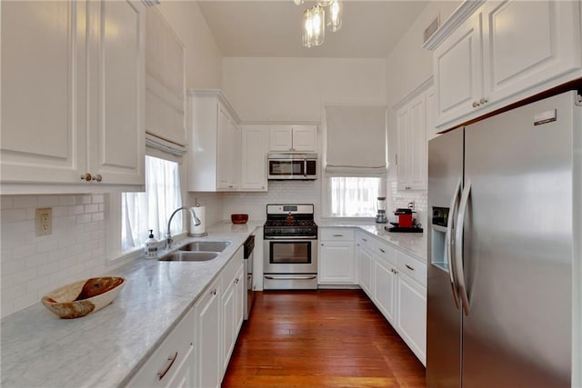 kitchen featuring appliances with stainless steel finishes, dark wood-type flooring, a healthy amount of sunlight, and sink