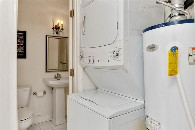 laundry area featuring gas water heater and stacked washer / drying machine