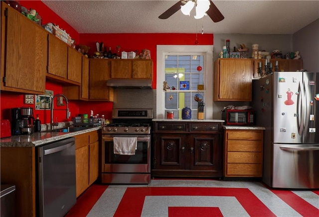 kitchen with ceiling fan, a textured ceiling, stainless steel appliances, and sink