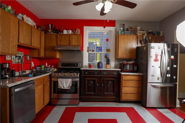 kitchen with a textured ceiling, ceiling fan, appliances with stainless steel finishes, and sink