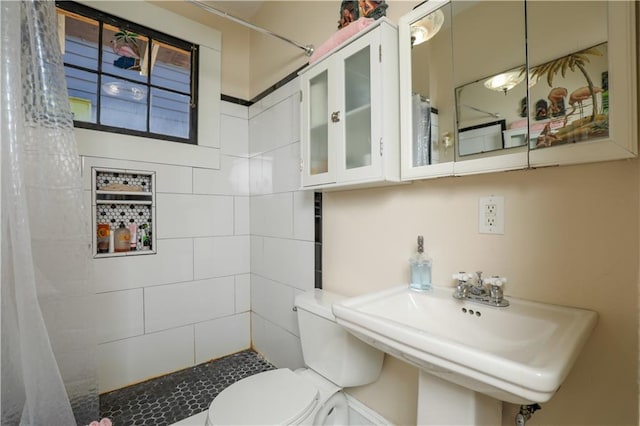 bathroom featuring toilet, a shower with shower curtain, and sink