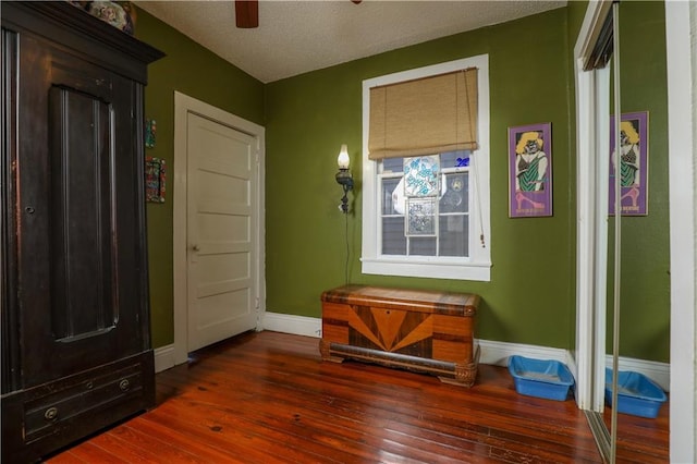 interior space featuring a textured ceiling, ceiling fan, and dark hardwood / wood-style flooring