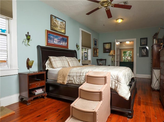 bedroom featuring ceiling fan, multiple windows, and dark wood-type flooring