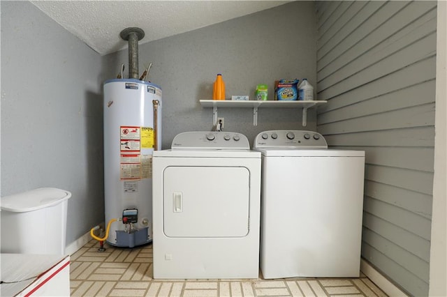 washroom featuring water heater, a textured ceiling, and washer and clothes dryer