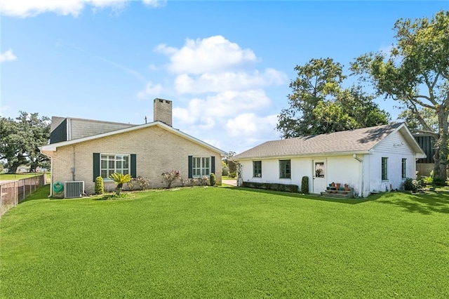 rear view of property featuring a yard and central AC