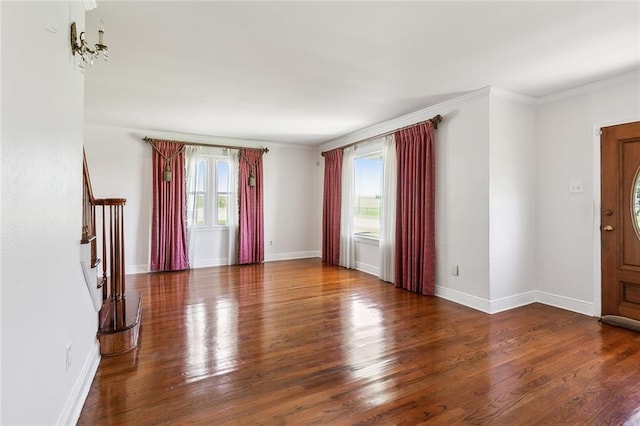 interior space featuring an inviting chandelier, dark wood-type flooring, a healthy amount of sunlight, and crown molding