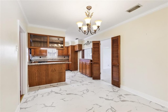 kitchen featuring backsplash, kitchen peninsula, pendant lighting, crown molding, and a chandelier