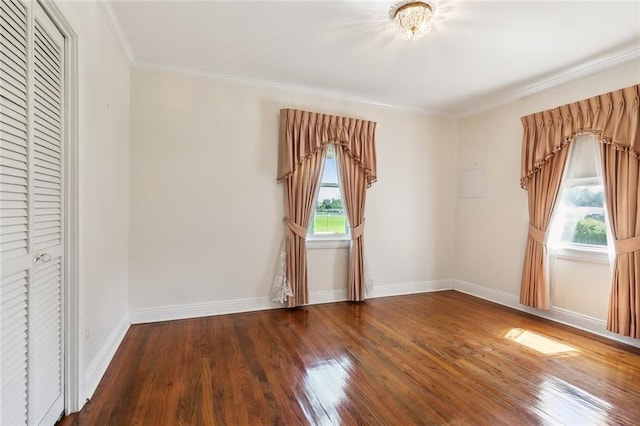 unfurnished bedroom with a closet, multiple windows, crown molding, and dark hardwood / wood-style flooring