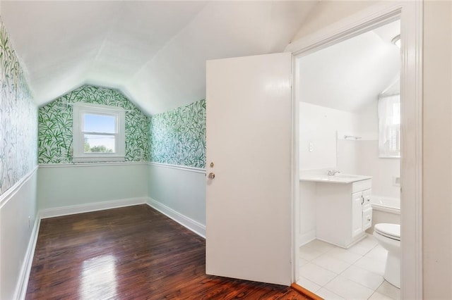 bathroom featuring vanity, toilet, vaulted ceiling, and hardwood / wood-style flooring