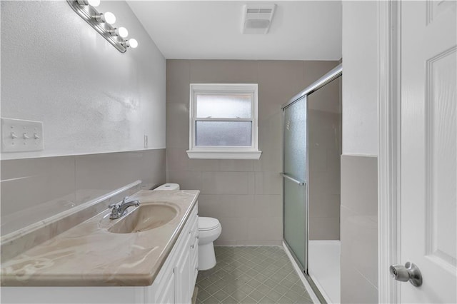 bathroom with an enclosed shower, vanity, toilet, and tile patterned floors