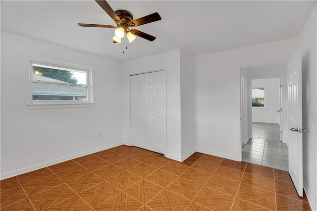 unfurnished bedroom with ceiling fan, tile patterned floors, and a closet