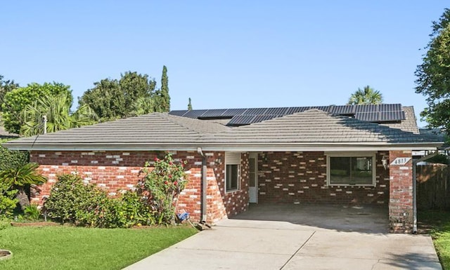 ranch-style house with a front yard and solar panels