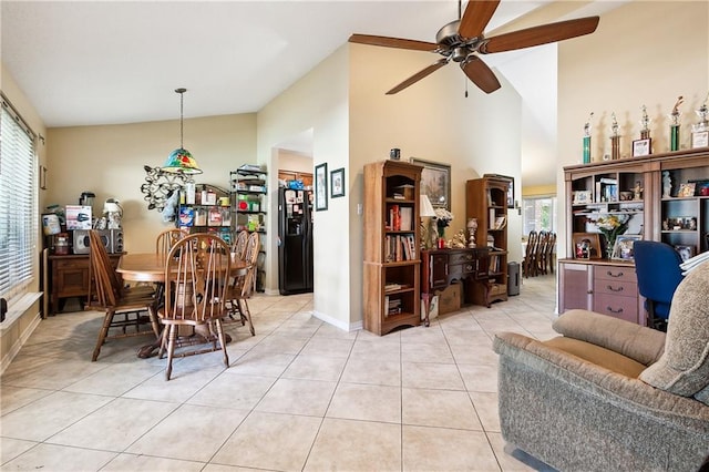 dining area with a wealth of natural light, light tile patterned floors, vaulted ceiling, and ceiling fan