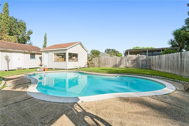 view of pool with a lawn and an outdoor structure