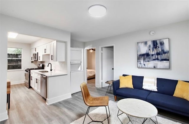 living room featuring light wood-type flooring and sink