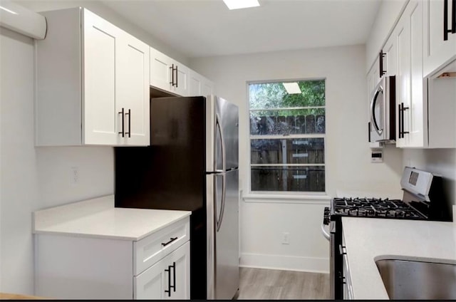 kitchen featuring light hardwood / wood-style flooring, appliances with stainless steel finishes, and white cabinetry