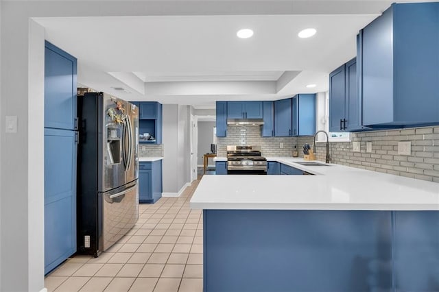 kitchen with blue cabinets, kitchen peninsula, appliances with stainless steel finishes, and sink