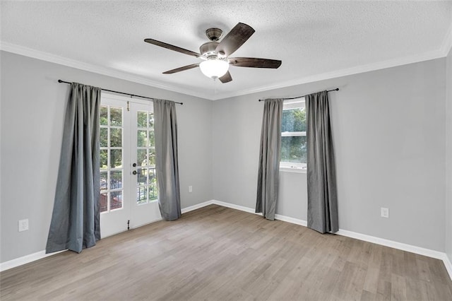 spare room featuring ornamental molding, light wood-type flooring, and plenty of natural light