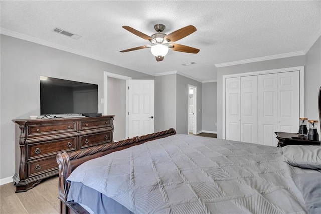 bedroom featuring ceiling fan, ornamental molding, a textured ceiling, and light hardwood / wood-style floors