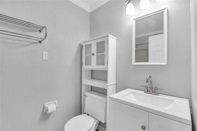 bathroom with ornamental molding, vanity, and toilet