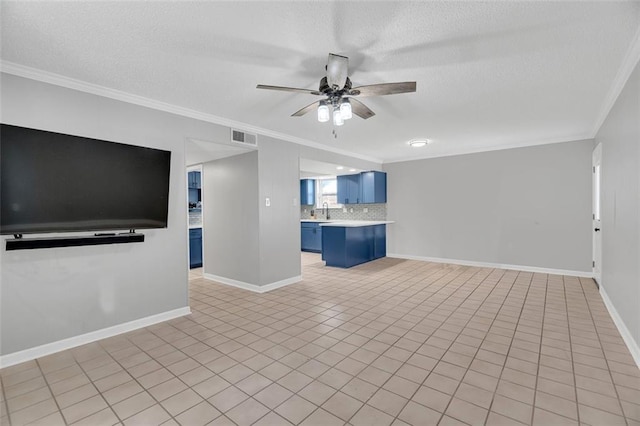 unfurnished living room with light tile patterned floors, a textured ceiling, crown molding, ceiling fan, and sink