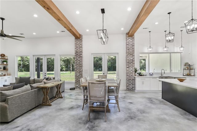 dining area featuring concrete floors, beamed ceiling, and french doors