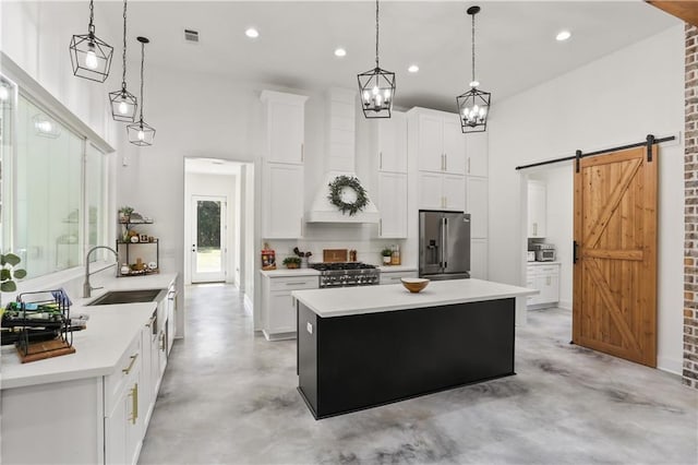 kitchen featuring appliances with stainless steel finishes, decorative light fixtures, sink, and white cabinets