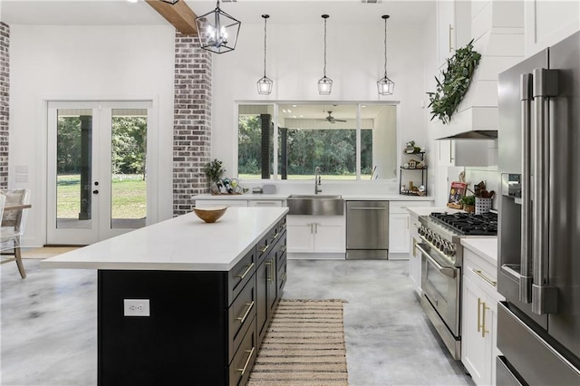 kitchen with a center island, hanging light fixtures, high quality appliances, and sink