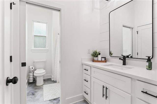 bathroom featuring concrete flooring, vanity, toilet, and curtained shower