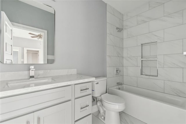 full bathroom with ceiling fan, vanity, tiled shower / bath combo, and toilet