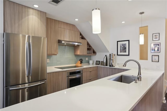 kitchen featuring sink, appliances with stainless steel finishes, hanging light fixtures, and kitchen peninsula