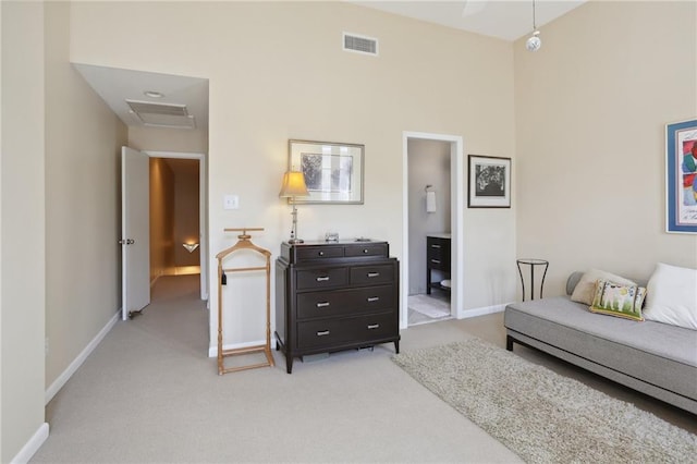 bedroom featuring ensuite bath and light colored carpet