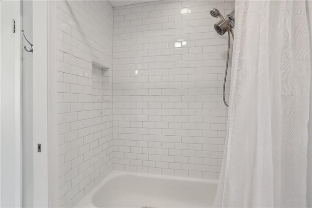 bathroom with shower / bath combo with shower curtain