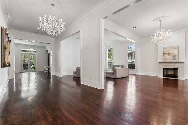 unfurnished living room with an inviting chandelier, ornamental molding, and dark hardwood / wood-style flooring