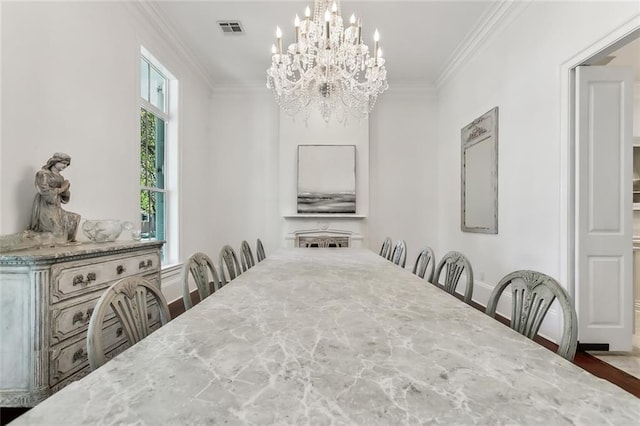 dining room with crown molding, hardwood / wood-style floors, and a chandelier